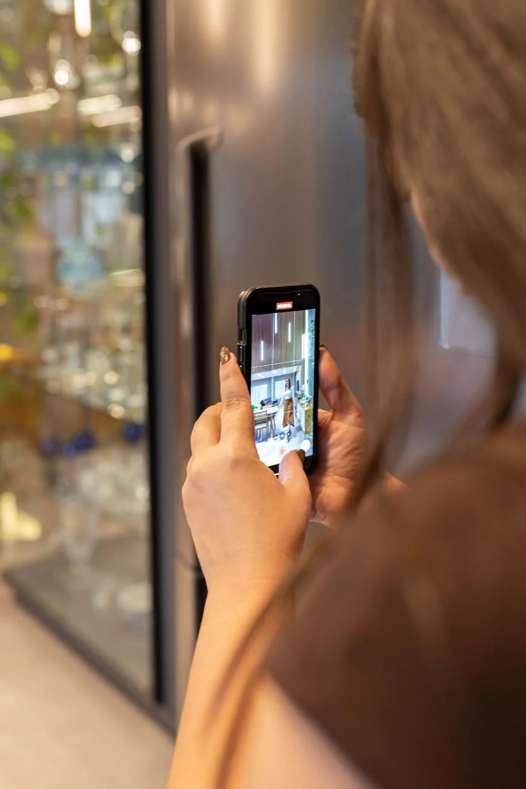 Letícia registra um ambiente com o celular durante uma criação de conteúdo