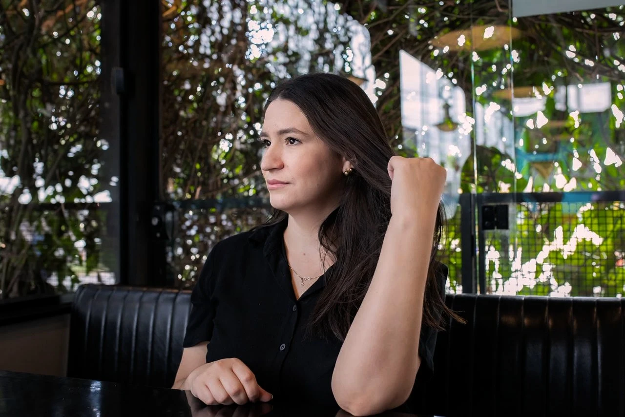 Letícia Sartor sentada em um ambiente cercado por vegetação